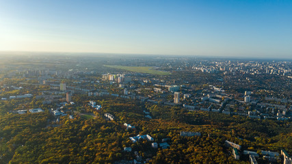 Fototapeta na wymiar Golden autumn Kyiv cityscape, aerial drone view of city skyline and forest with yellow trees and beautiful landscape from above, Kiev, Goloseevo forest, Ukraine 