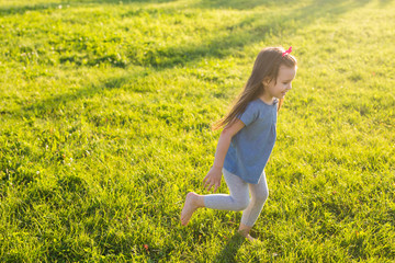 Fototapeta premium Little happy girl having fun in a summer park.