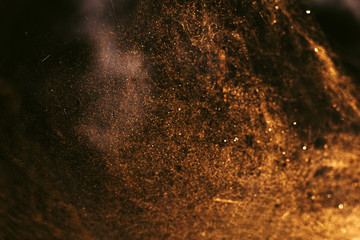 abstract golden festive blurred background with white round bokeh,fuzzy spiderweb in the sunlight with drops of water