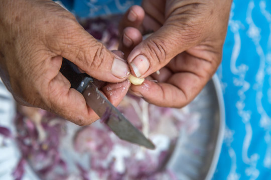 Woman peeling garlic by hand for cooking