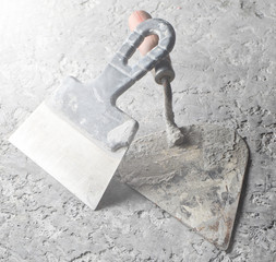 Building tools on a gray concrete background. Spatula, trowel..