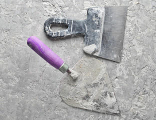 Building tools on a gray concrete background. Spatula, trowel, top view..