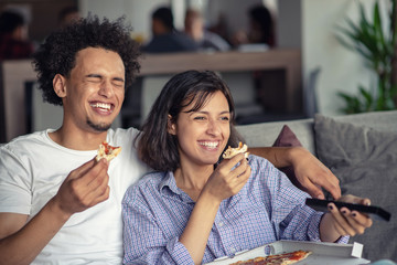 Young Couple with pizza and TV remote