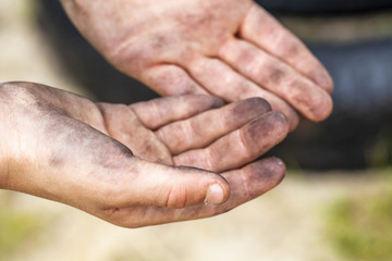 Closeup of young man dirty hands and tyre outdoors