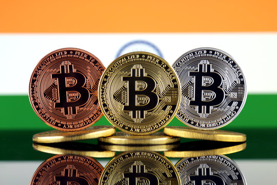 Physical version of Bitcoin (BTC) and India Flag. Conceptual image for investors in High Technology (Cryptocurrency, Blockchain Technology, Smart Contracts, ICO).