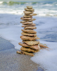 Fototapeta na wymiar Stone tower in the sea waves