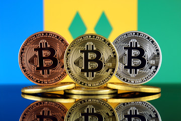 Physical version of Bitcoin (BTC) and Saint Vincent and The Grenadines Flag. Conceptual image for...
