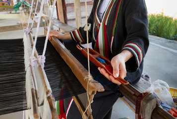 Close up of black silk weaving on loom, selective focus