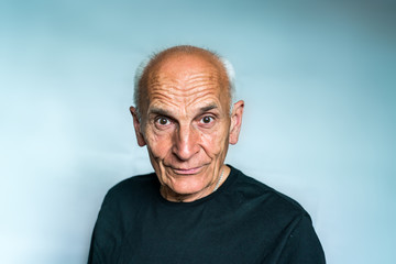 An elderly man with gray hair, piercing looks ahead