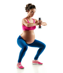 Sporty pregnant girl  squatting doing sit-ups with dumbbell isolated on white background. Concept...