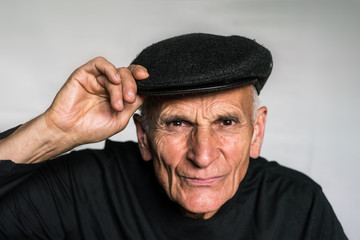 An elderly man in a cap, a brazen, defiant, unpleasant look