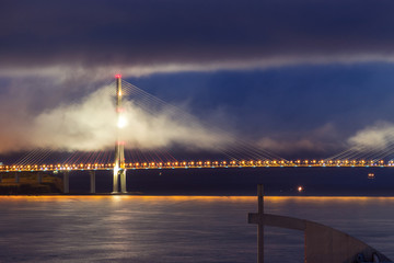 Night view of the support of the large cable-stayed bridge, low clouds. 