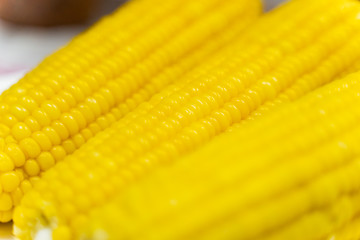 Three Fresh corn on white table, closeup.