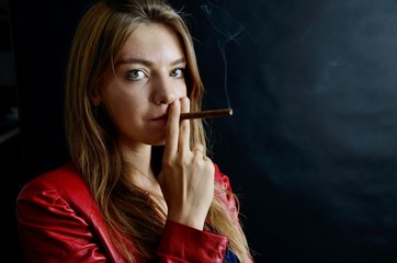 Obraz premium Young female smoking cigarillo