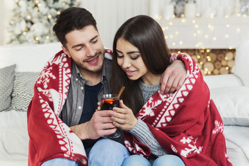 Couple relaxing with glass of warm wine on winter evening