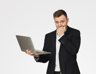 Stressed businessman in suit using laptop at work