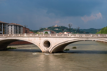 Old historical bridge Ponte della Vittoria across the Adige River in the center of Verona. On the...