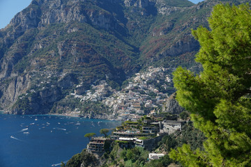 AERIAL Picturesque view of idyllic Positano coast and boats sailing the ocean.