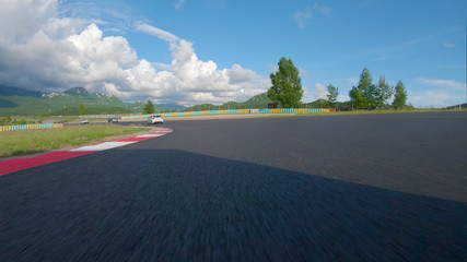 POV: Speeding through the curves of a cool asphalt racetrack during a race.