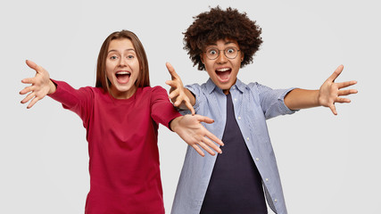 Photo of amazed mixed race women best friends give warm hug at camera, notice close people in...