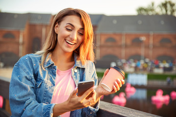 Cute girl talking on Skype, communicates remotely with friends using the phone. Woman surprised by...