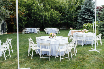 Wedding. Banquet. Chairs and honeymooners table decorated with candles,