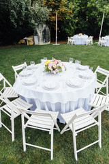 Wedding. Banquet. Chairs and honeymooners table decorated with candles,