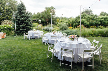 Wedding. Banquet. Chairs and honeymooners table decorated with candles,