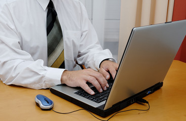 Young businessman in a white shirt with laptop