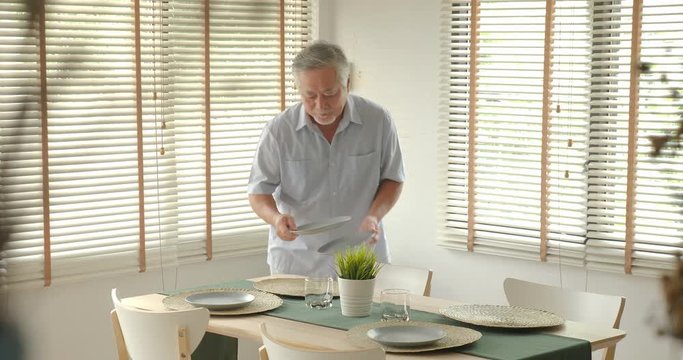 Senior man preparing the table for a dinner party with happy emotion. old age, retirement, senior lifestyle family concept.