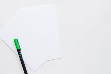 Blank paper card with pen on white background for workspace concept