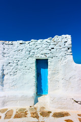 Narrow door in ancient whitewashed wall