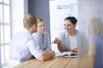 Young people studying with books on desk. Beautiful women and men working together.