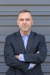 Confident middle age businessman over gray