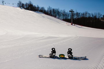 Bottom view on empty ski slope and equipment for snowboarding