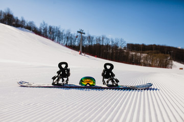 Bottom view on empty ski slope and equipment for snowboarding