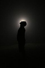 Silhouette in the Dark, Head Leaning Backwards with Open Mouth. Light behind Head.