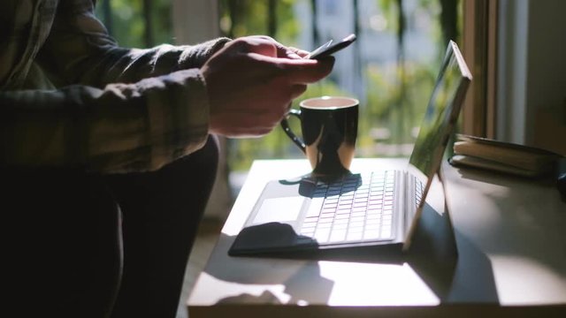 Medium Shot Of Male Hands Paying With Credit Card And Mobile Phone At Home, Cup Of Coffe And Laptop In The Background, Shot In 4K UHD