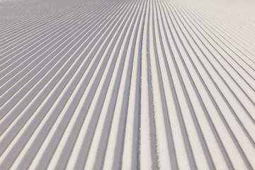 Texture of new groomed snow on empty ski slope