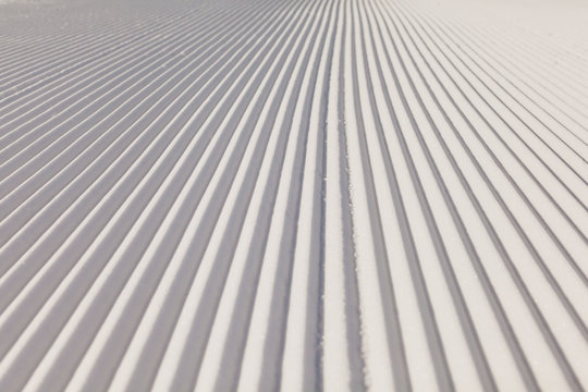 Texture of new groomed snow on empty ski slope
