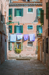 Fototapeta na wymiar Historical architecture and landmarks in Venice old town in Italy. Narrow streets with colorful buildings surrounded by tourists. Beautiful scenery of romantic canals and boats.