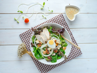 One big ceramic bowl of ceasar salad with ceasar dressing cream.