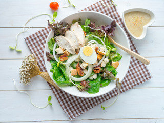 One big ceramic bowl of ceasar salad with ceasar dressing cream.
