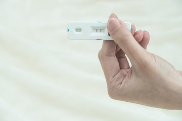 Pregnancy test with positive pregnant in  women hand with blurred baby background: Concept of family