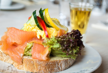 Sandwich with smoked salmon and fresh vegetables, in natural light. Concept for healthy nutrition. close-up