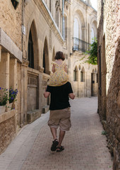 Fototapeta na wymiar Padre e hija caminando por una calle en un pueblito de Francia