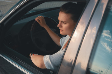 Young woman in casual wear Put Head Out of Window  while driving
