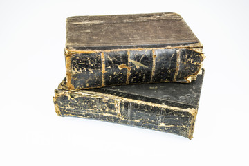 Two antique, chabby thick hardback books brown color on a white background.