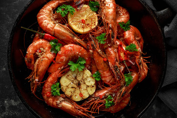 Tiger prawns fried in butter with, lemon juice, garlic and white wine served in cast iron skillet with parsley