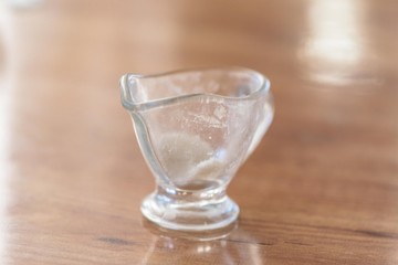 glass vase for sauce is on the table wooden texture